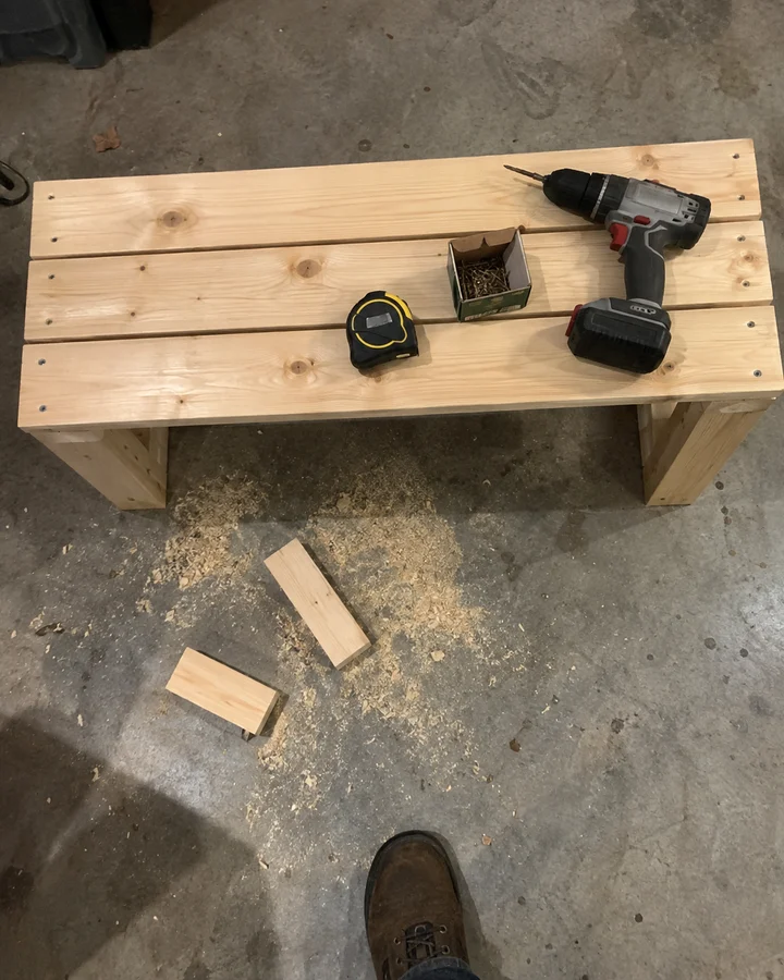 A freshly built pine garden bench on a garage floor, seen from above